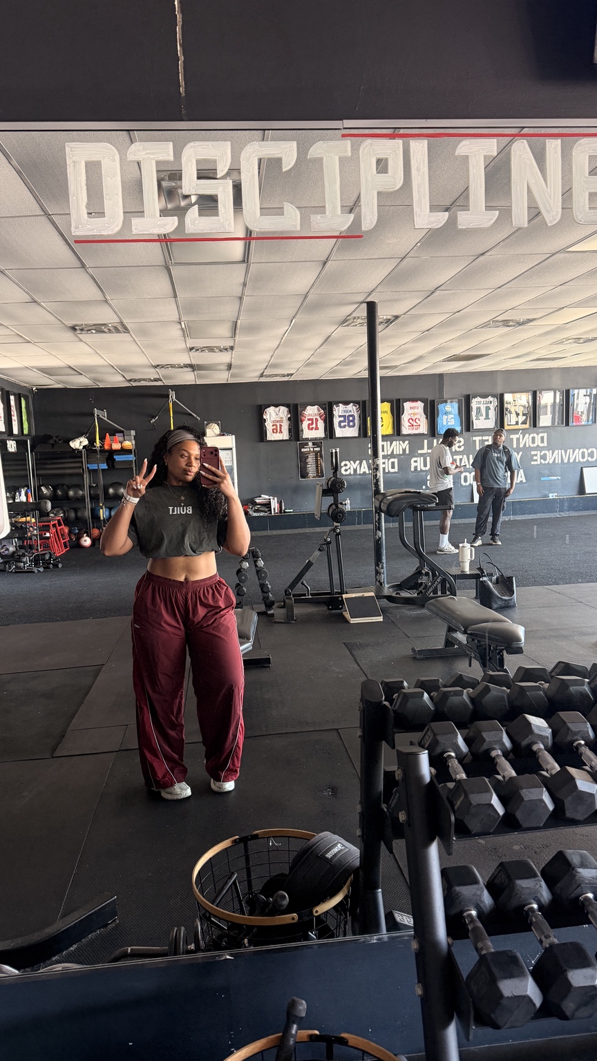 Sydney at the gym surrounded by strength training equipment
